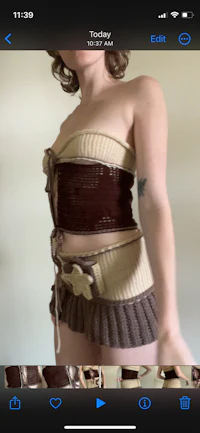 a woman is posing in a brown and white outfit