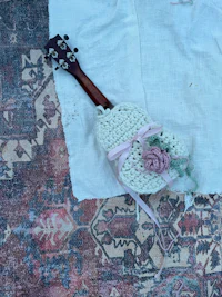 a crocheted guitar laying on a rug
