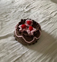 a crocheted cake sitting on top of a bed