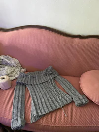 a grey sweater on top of a pink couch