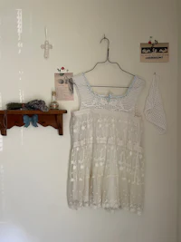 a white lace dress hanging on a wall