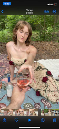 a woman in a dress is holding a glass of wine