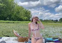 a woman in a bikini sitting on a boat in a lake