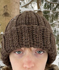 a woman wearing a brown crocheted hat in the snow
