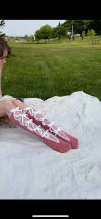 a woman is sitting on a blanket in a field