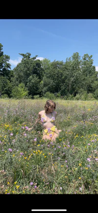 a woman sitting in a field of wildflowers