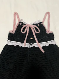 a black crocheted dress with pink trim