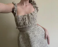 a woman is taking a selfie in a tweed dress